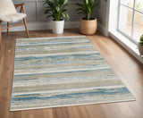 4' X 6' Ivory Beige Grey Blue And Tan Abstract Power Loom Stain Resistant Area Rug With Fringe