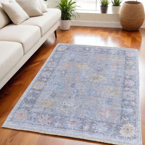 5' X 8' Orange Blue and Gold Floral Hand Woven Distressed Area Rug With Fringe